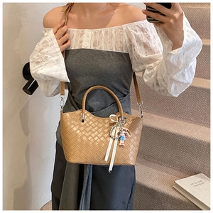 Detail of camel woven leather tote with pearl charms and detachable shoulder strap