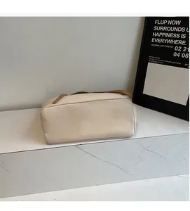 Detail of minimalist beige canvas tote bag with brown handles on marble surface