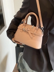 Chic pale pink pebbled leather handbag with double handles and adjustable crossbody strap