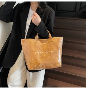 Dettaglio della borsa TOTE BAG marrone impermeabile con finitura in PVC lucido e scritte