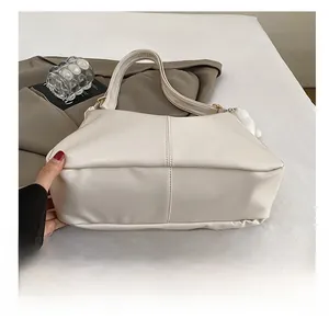 Detailed close-up showing the wear-resistant reinforced bottom of this white tote bag