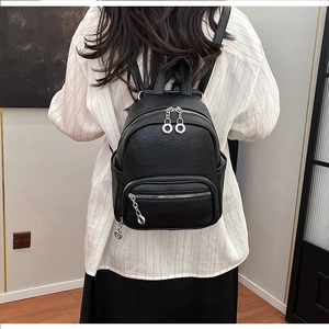 Close-up of black litchi pattern mini backpack showing size and silver zipper hardware