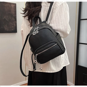Detail of black lychee grain leather mini backpack with silver metal zipper and ring decor