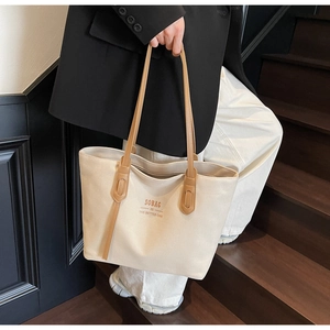 Detail of canvas tote bag with brown straps and Sobag brand print on the front