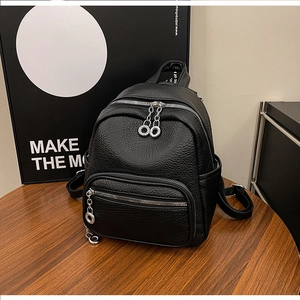 Close-up of the black pebble grain faux leather texture and silver chain on mini backpack