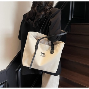 Detailed shot of large canvas tote bag with black handles and SOBAG slogan print