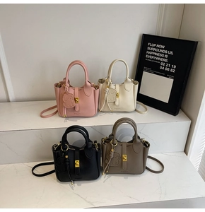 Detail of lychee pattern leather bucket bags with gold handle locks and dog charms