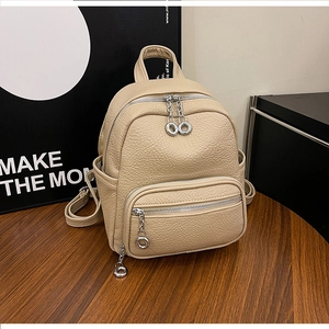 Close-up of beige soft leather mini backpack with textured finish and silver zippers