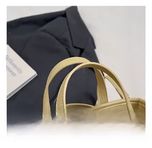 Close-up of litchi grain beige leather handbag with professional stitching and metal hardware
