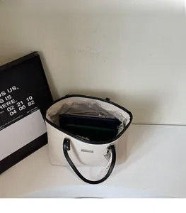 Detail view of large canvas tote bag showing interior storage capacity and black faux leather trim