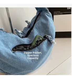 Detail view of the side zippered pocket on the denim bag showing large storage capacity