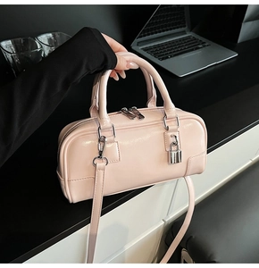 Detail of pink patent leather boston bag with glossy finish and silver hardware