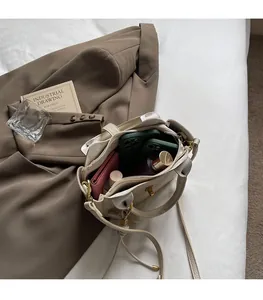 Spacious interior of beige pebbled leather bucket bag showing large storage capacity