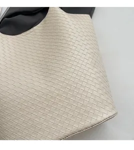Detaillierte Nahaufnahme der hochwertigen Intrecciato-Webstruktur der cremeweißen Tasche