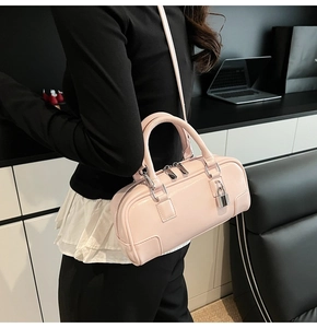 Detail of pink patent leather Boston bag featuring silver padlock and reinforced corners