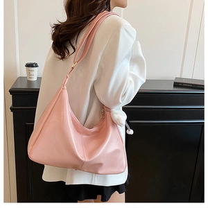 Woman wearing pink large leather hobo bag with plush charm for casual street style