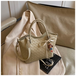 Close-up of the woven leather texture and elegant ribbon bow detail on a handbag