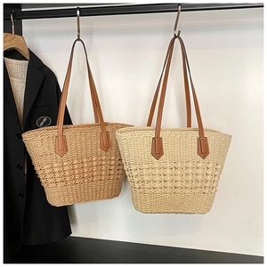 Detail of woven straw tote bags in khaki and beige with premium brown leather handles