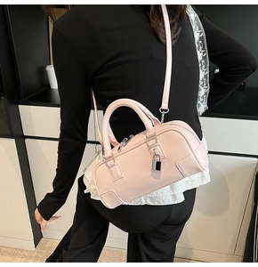 Pink faux leather bowling handbag shown from a rear perspective on a model