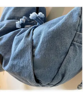 Detail of light blue denim fabric texture with frayed edges and soft cotton twill
