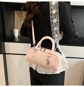 Detail of light pink Boston bag showing matte leather texture and silver padlock