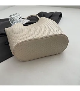 Detaillierte Draufsicht auf beige geflochtene Hobo-Tasche mit flachem Boden und Webstruktur