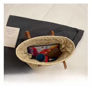 Top view of spacious straw tote bag showing internal storage for tablet and cosmetics