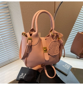 Pink lychee grain leather handbag with gold metal clasp and dog charm detail