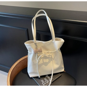 Dettaglio borsa tote in ecopelle bianca stropicciata con fiocco e catena di perle