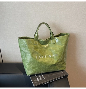 Dettaglio della borsa tote verde in Tyvek con finitura lucida impermeabile e testo bianco