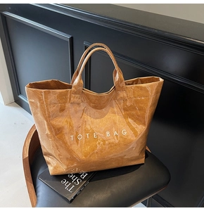 Dettaglio della borsa tote marrone in Tyvek con rivestimento in PVC lucido e scritta bianca