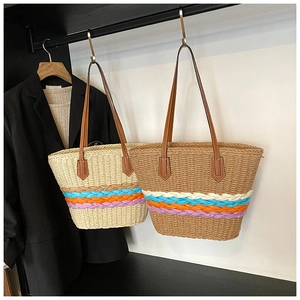 Dettaglio borsa tote in paglia intrecciata con decoro bohémien colorato e manici in pelle