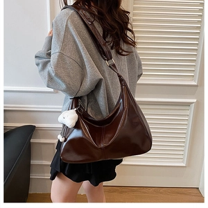 Macro shot of dark brown glossy PU leather tote bag with cloud charm detail
