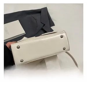 Detailed view of the off-white bucket bag base with four protective silver metal studs