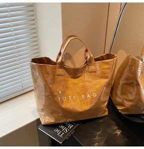 Dettaglio della borsa tote marrone con trama effetto carta e strato impermeabile in PVC