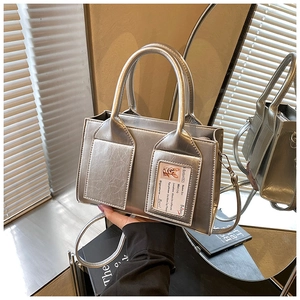 Close-up of metallic silver bucket bag with cracked texture and front card pocket detail