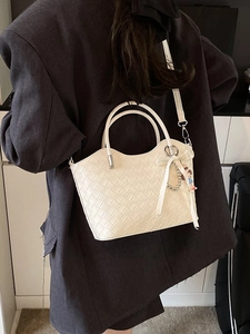 Quilted beige woven tote bag with bow detail and adjustable shoulder strap for women