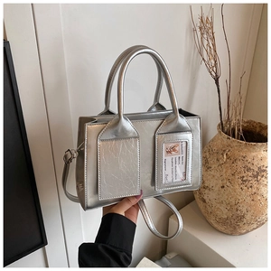 Close-up of silver bucket bag featuring a unique transparent ID card slot and decorative card