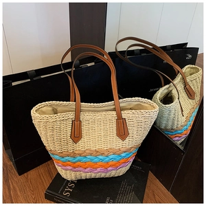 Détail d'un cabas en paille tissée avec rayures colorées et anses en cuir marron