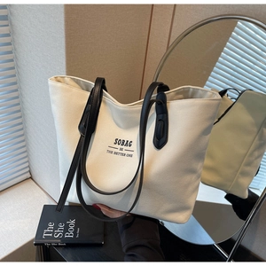 Detail of Sobag canvas tote bag with dual leather handles and black logo lettering