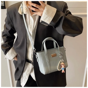 Light blue bucket bag with leather texture and cute pearl doll charm accessory