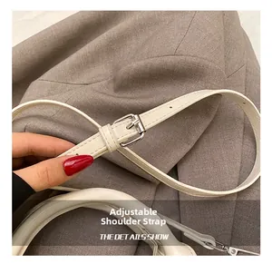 Detail of adjustable white leather shoulder strap with silver buckle for Boston bag