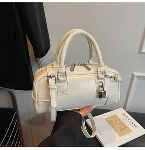 Detail of cream white leather Boston bag featuring silver hardware and top handle