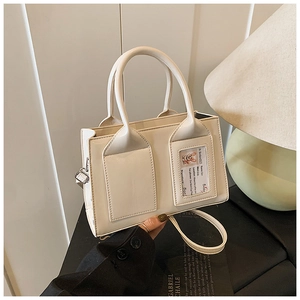 Detail of warm white leather bucket bag with dog card slot and silver hardware