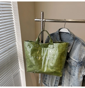 Detail der grünen Tyvek-Einkaufstasche mit glänzender Textur und TOTE BAG Aufdruck