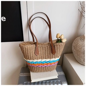 Détail du sac cabas en paille tressée avec rayures multicolores et anses en cuir marron