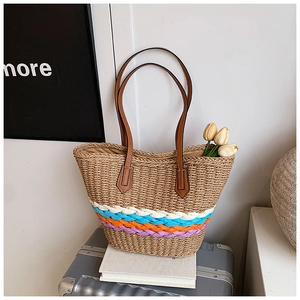 Détail d'un sac cabas en paille tissé avec base à rayures et anses en cuir