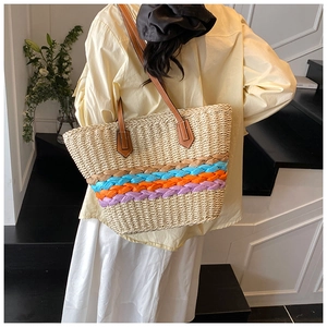 Détail du sac cabas en paille tissé à la main avec rayures colorées et anses en cuir