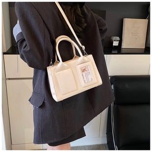 Detail view of cream bucket bag with unique front card slot and adjustable strap