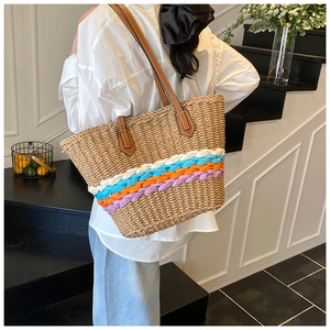 Détail du sac cabas en paille tissé à la main avec accents colorés et anses en cuir